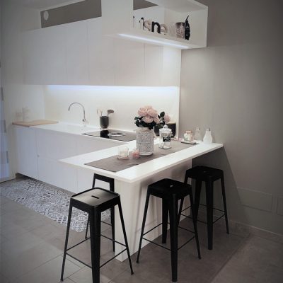 cucina moderna con piano bianco e sgabelli