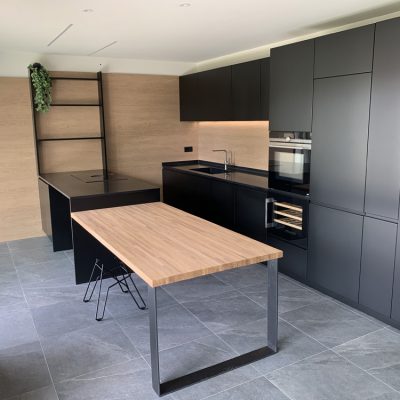 cucina moderna con piano in legno e arredamento nero